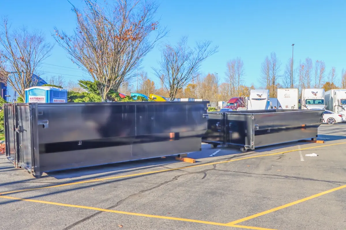 Professional dumpster rental service with roll-off container on residential driveway in Barnstead